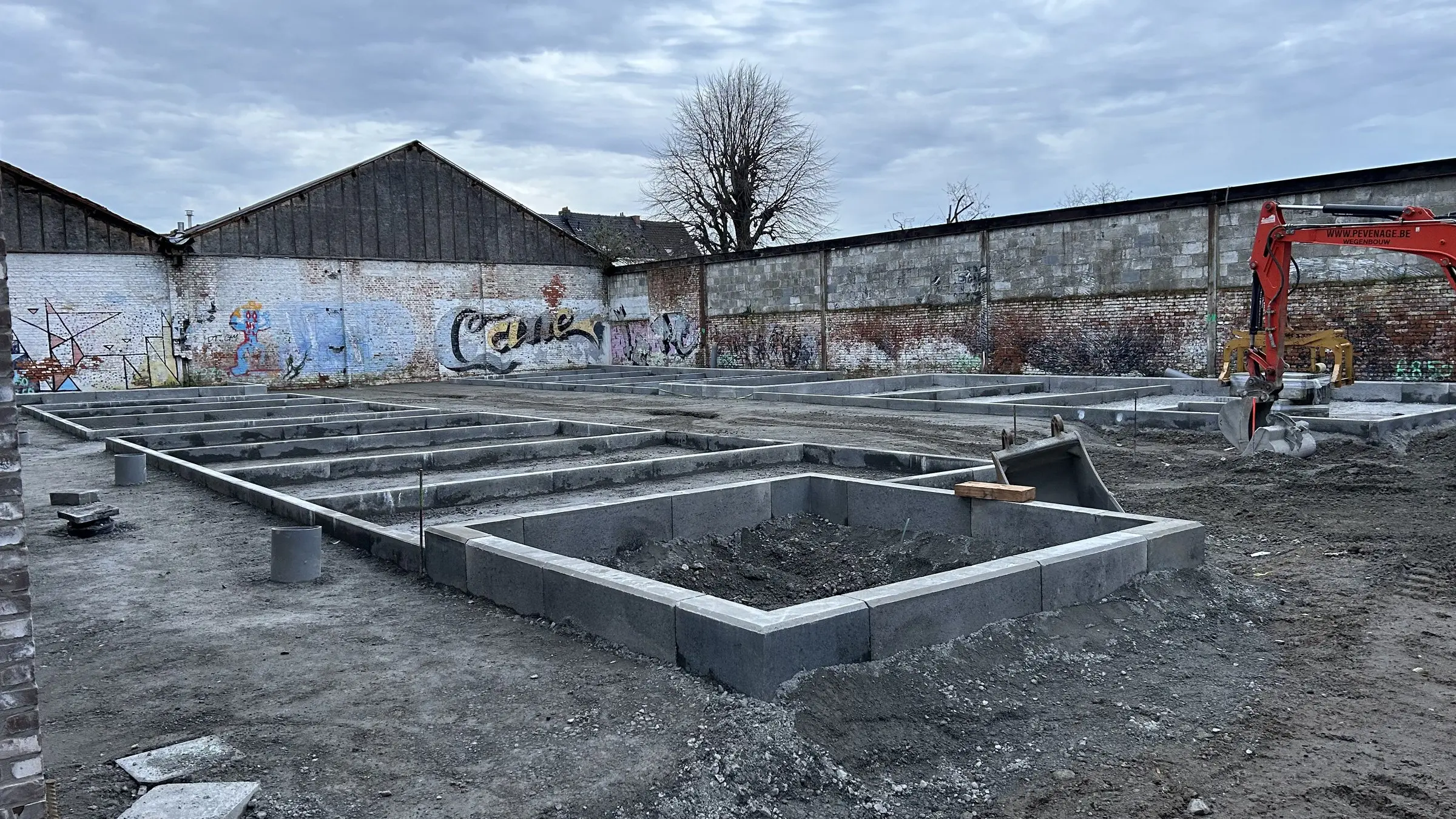 Boordstenen van de parkeervakken voor een gegraffitieerde muur
