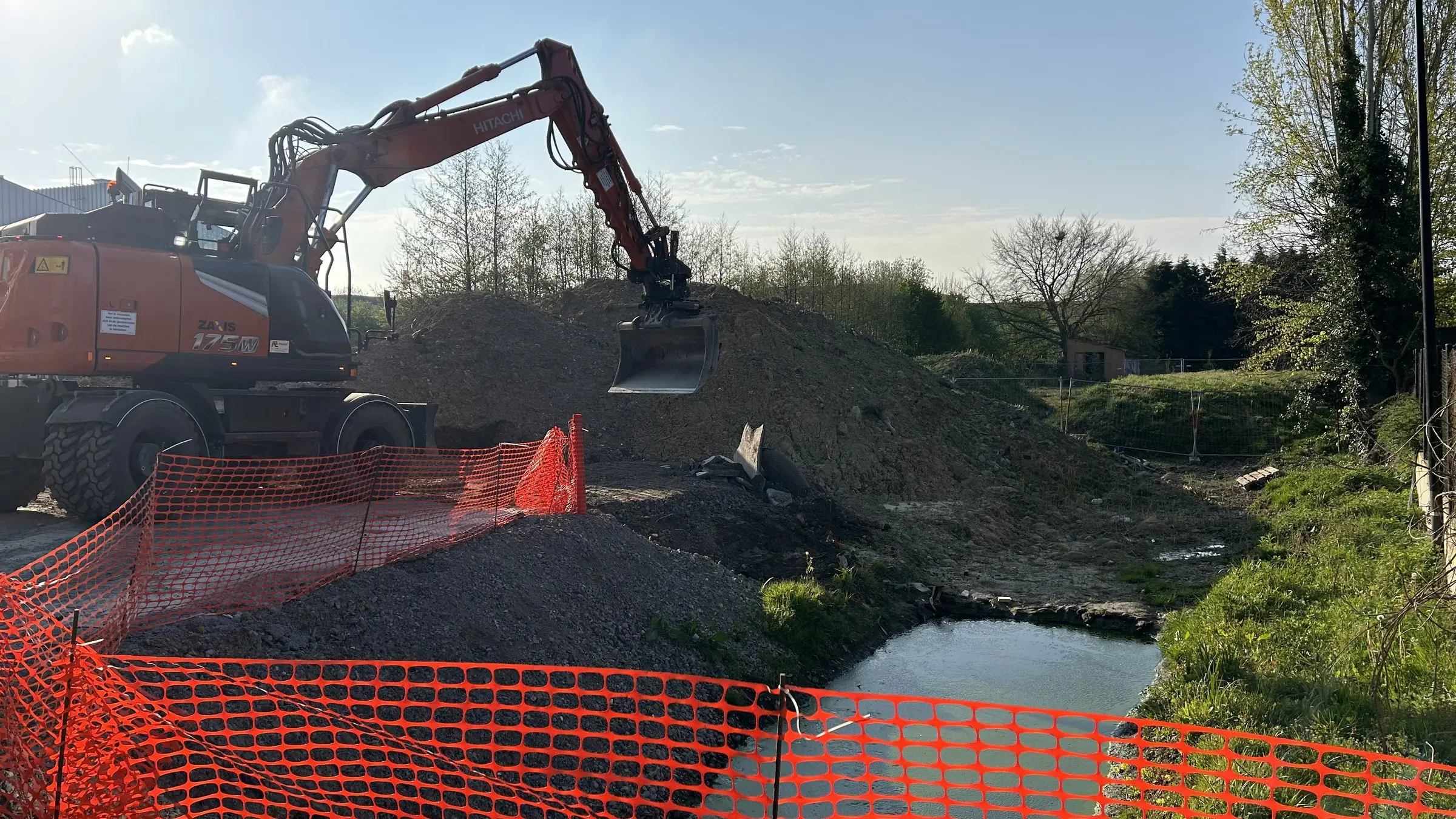 Kraan en oranje afsluiting langs het water