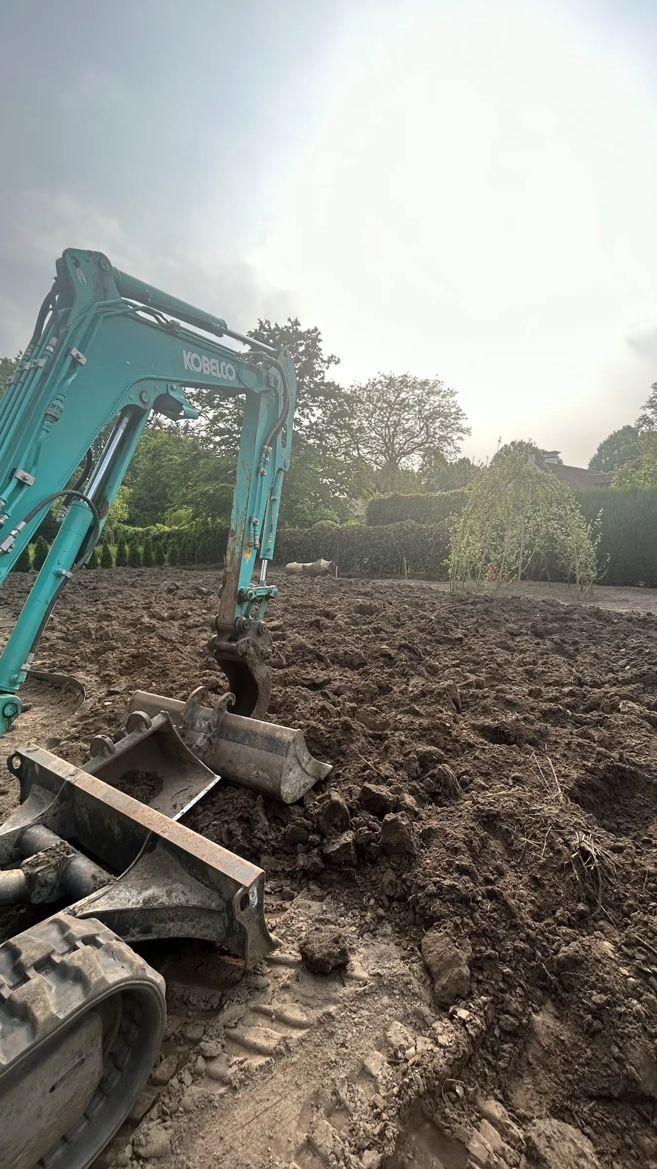 Minigraver bij het ontgraven van een tuin