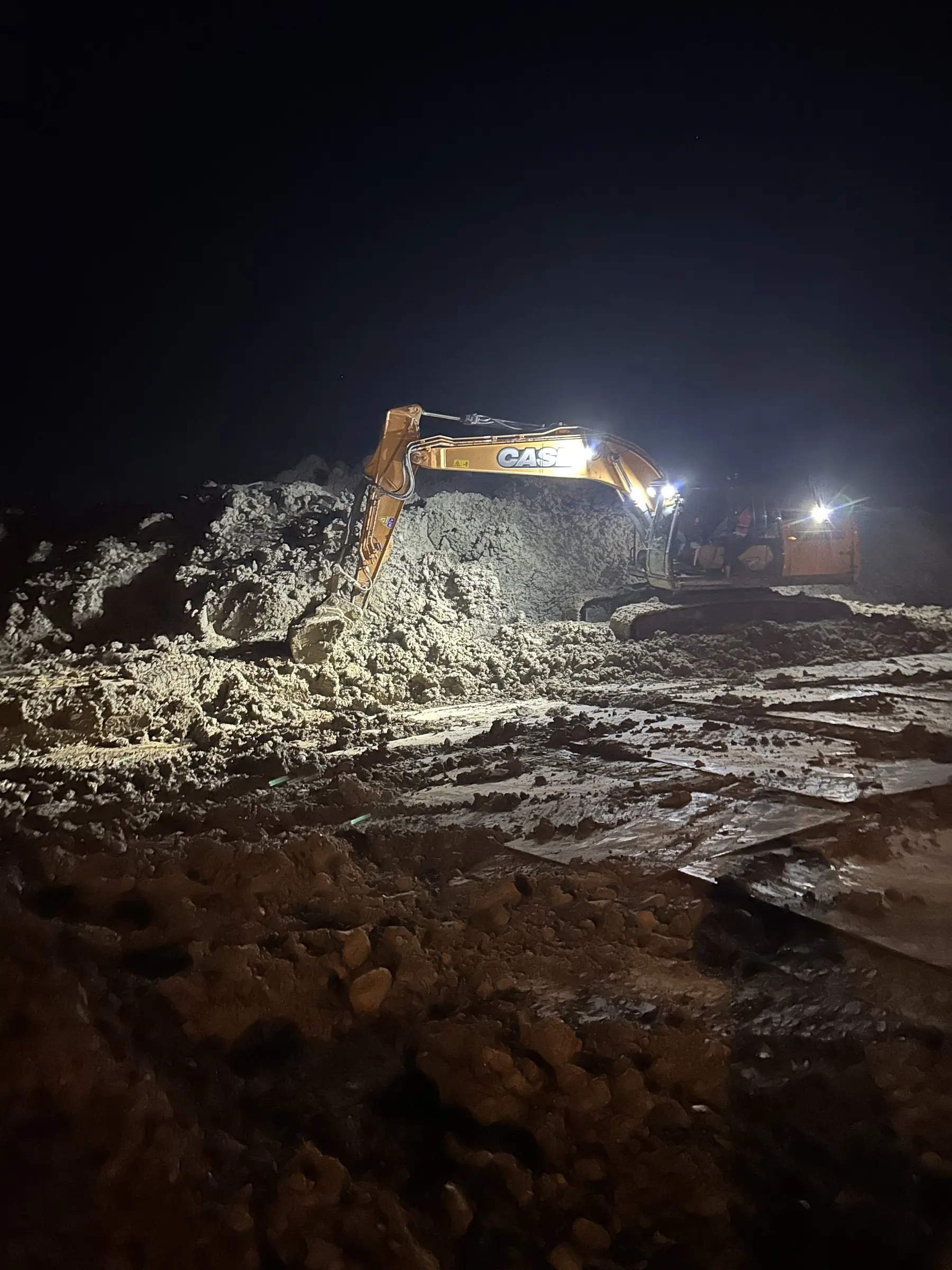Graafmachine bij nacht onder werklicht