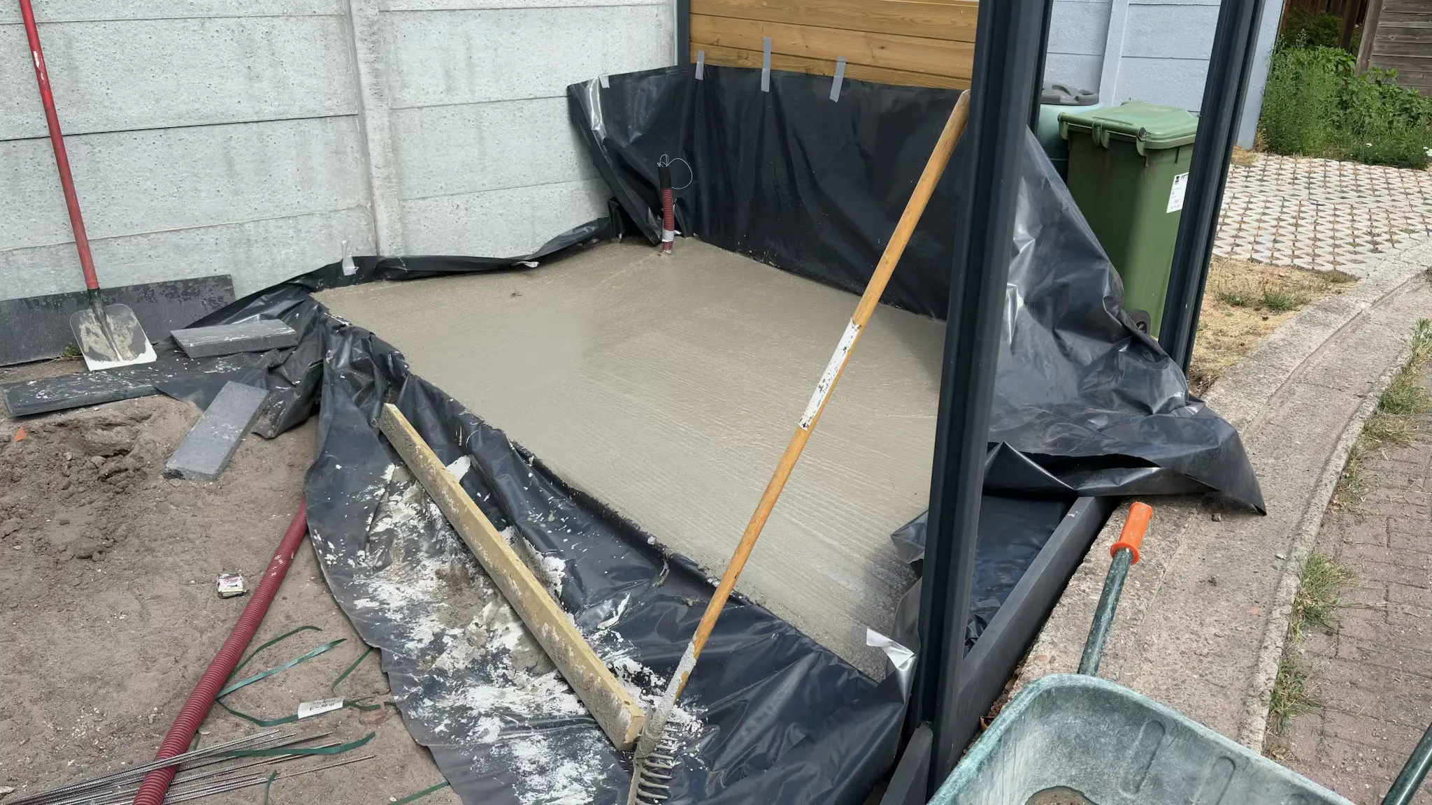 Terrasplaat gegoten op folie tegen de scheidingsmuur