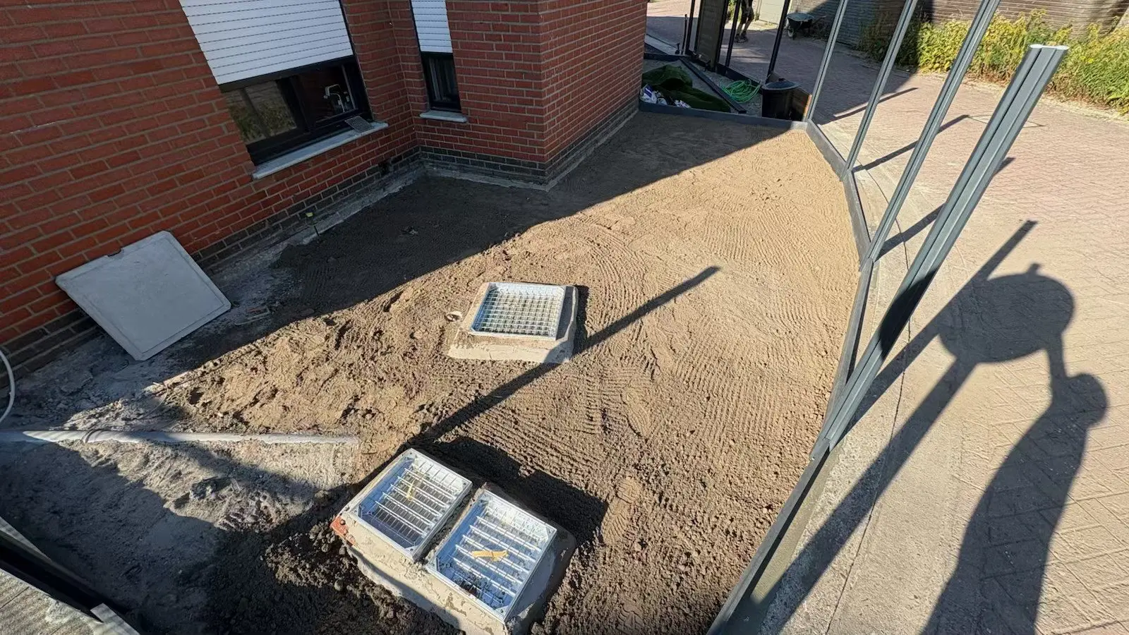 Afgevlakte zandgrond met controleputten in de tuin