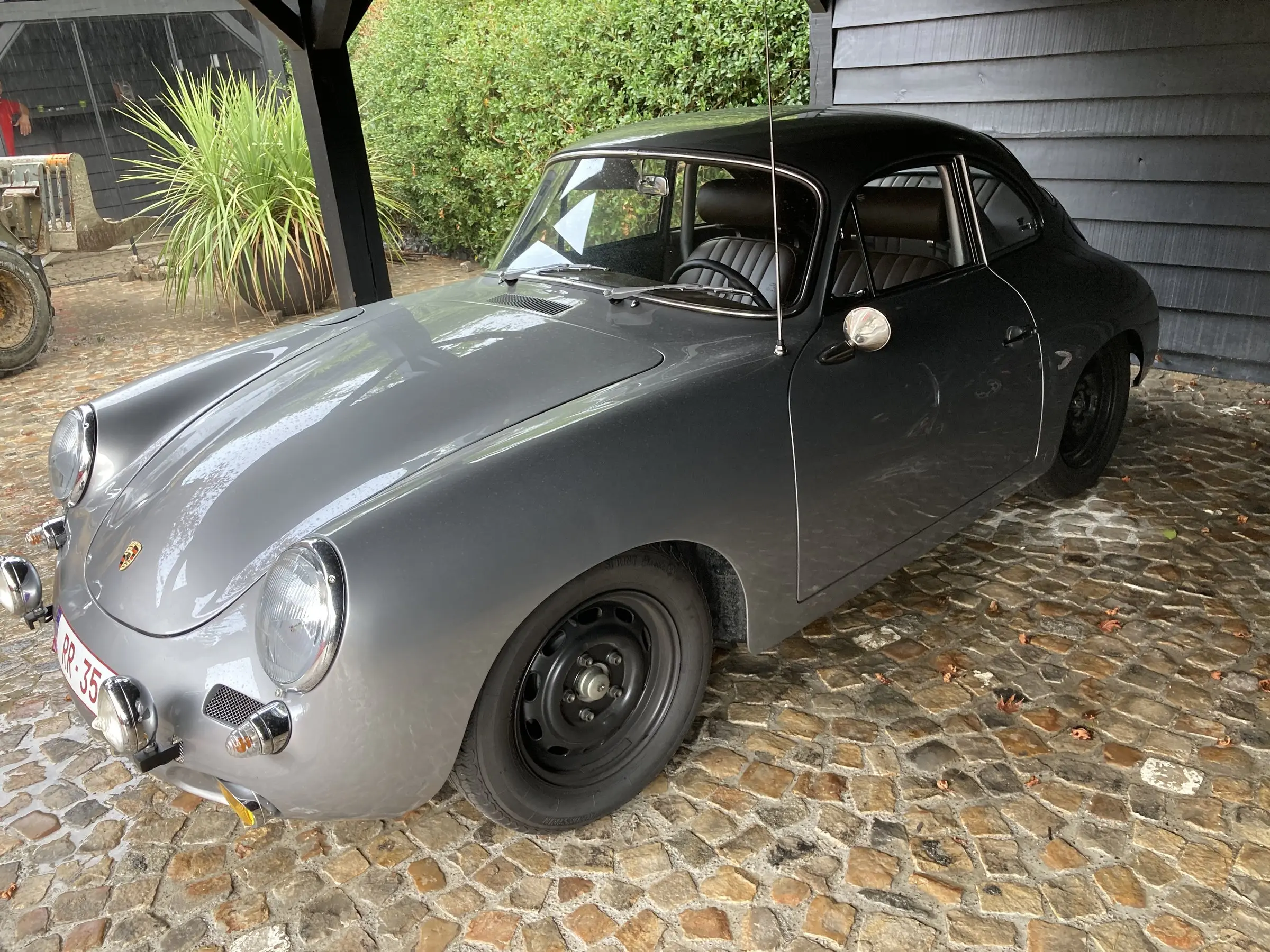 Oude kasseien onder de carport, met een klassieker geparkeerd