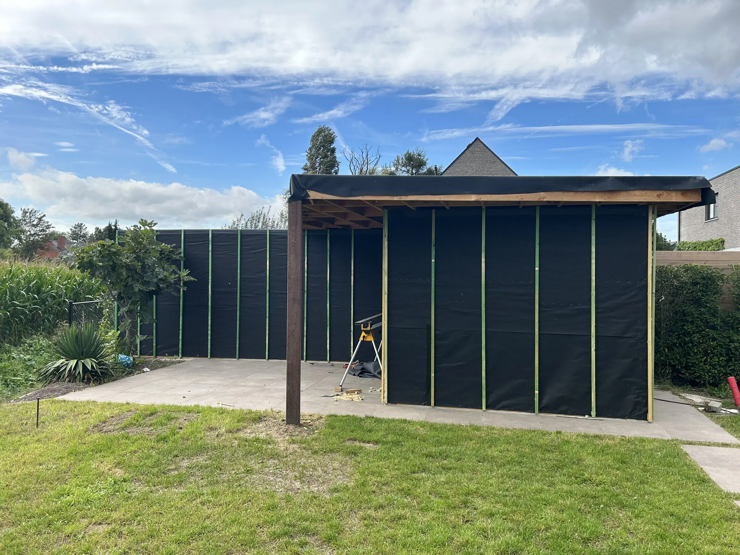 Poolhouse met open zijde en dakoverstek in de tuin