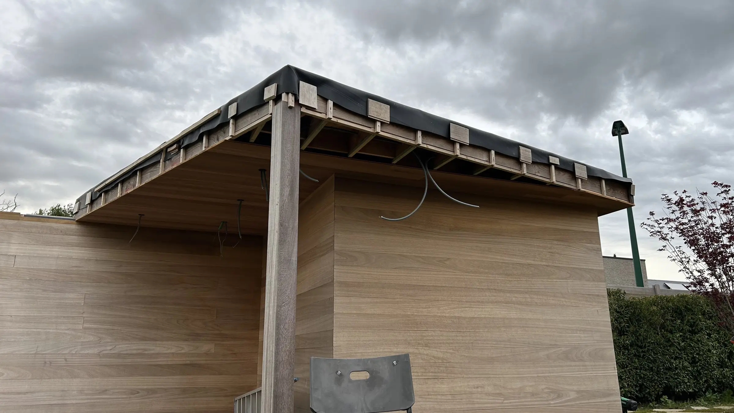 Dakrand en hout bekleding van het poolhouse van dichtbij