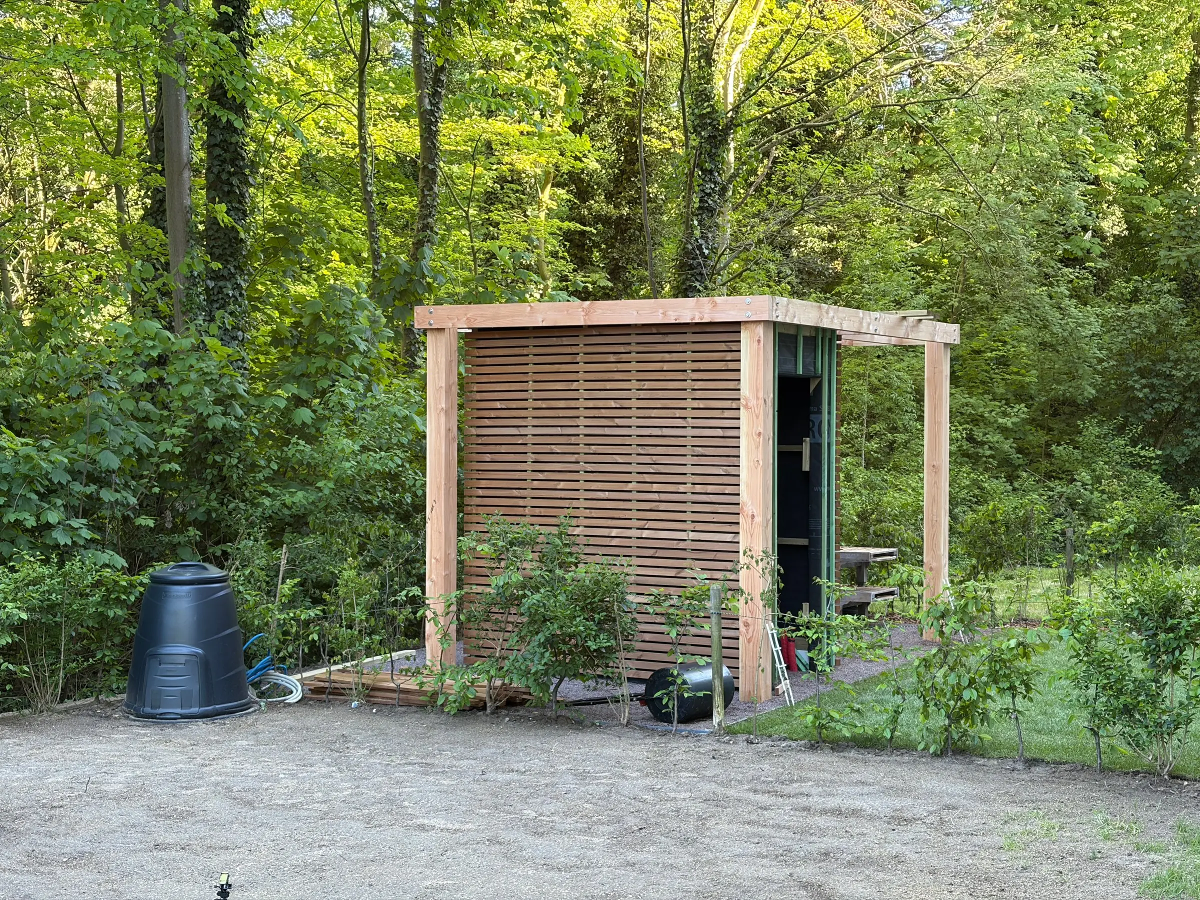 Houten tuinhuis met pergola aan de rand van het bos