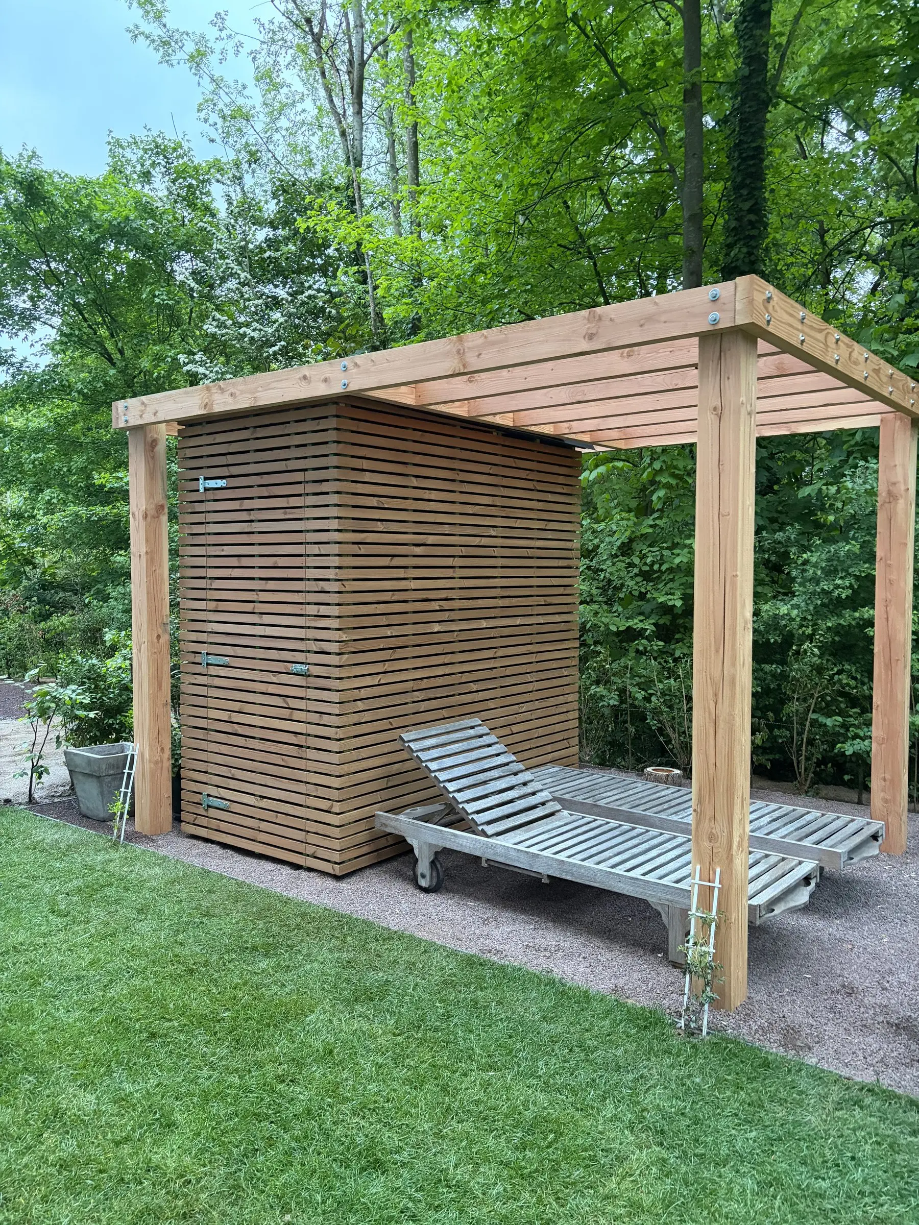 Pergola met ligbedden op het pas gelegde gras