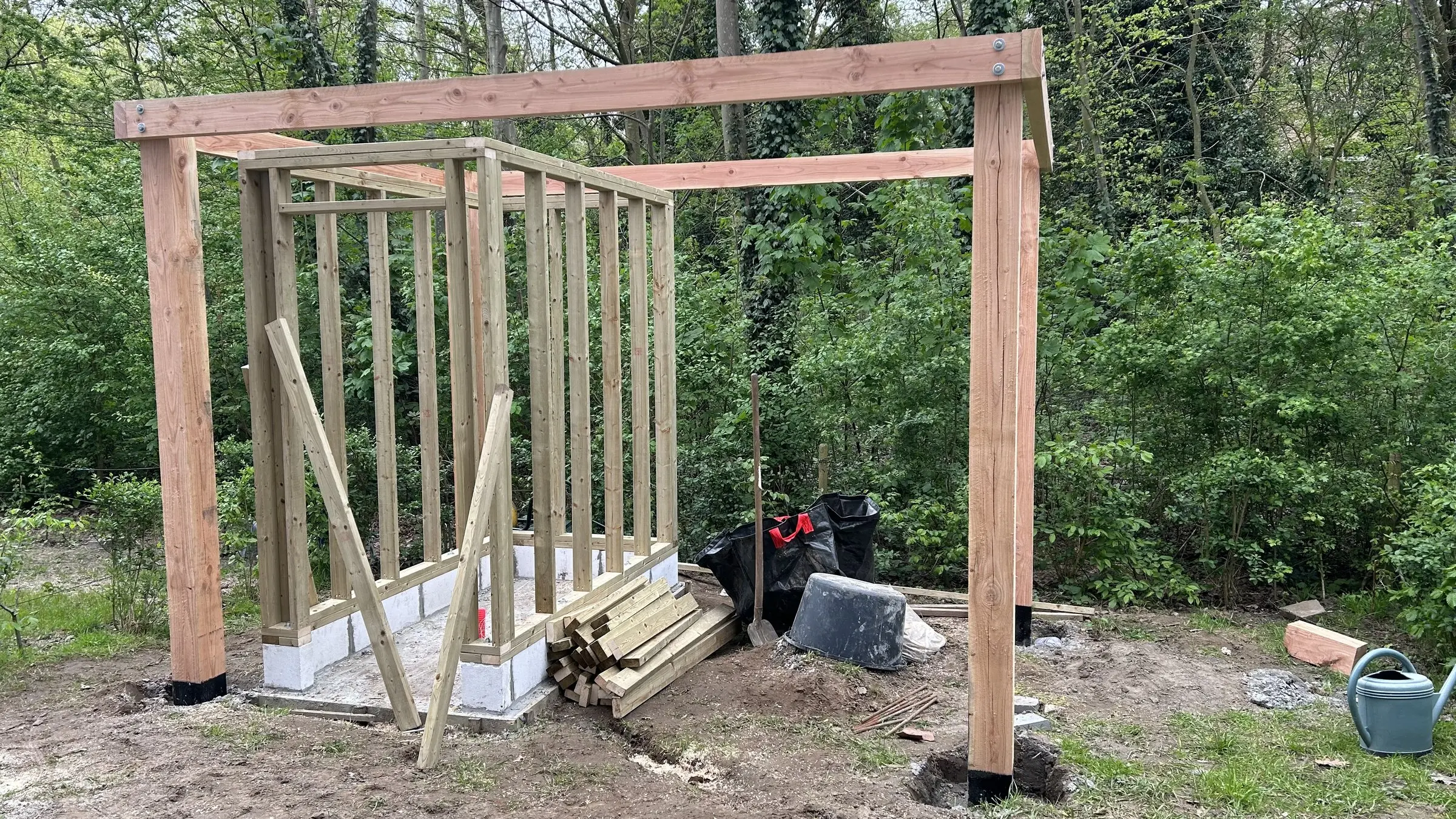 Houten skelet van het tuinhuis onder de pergolabalken