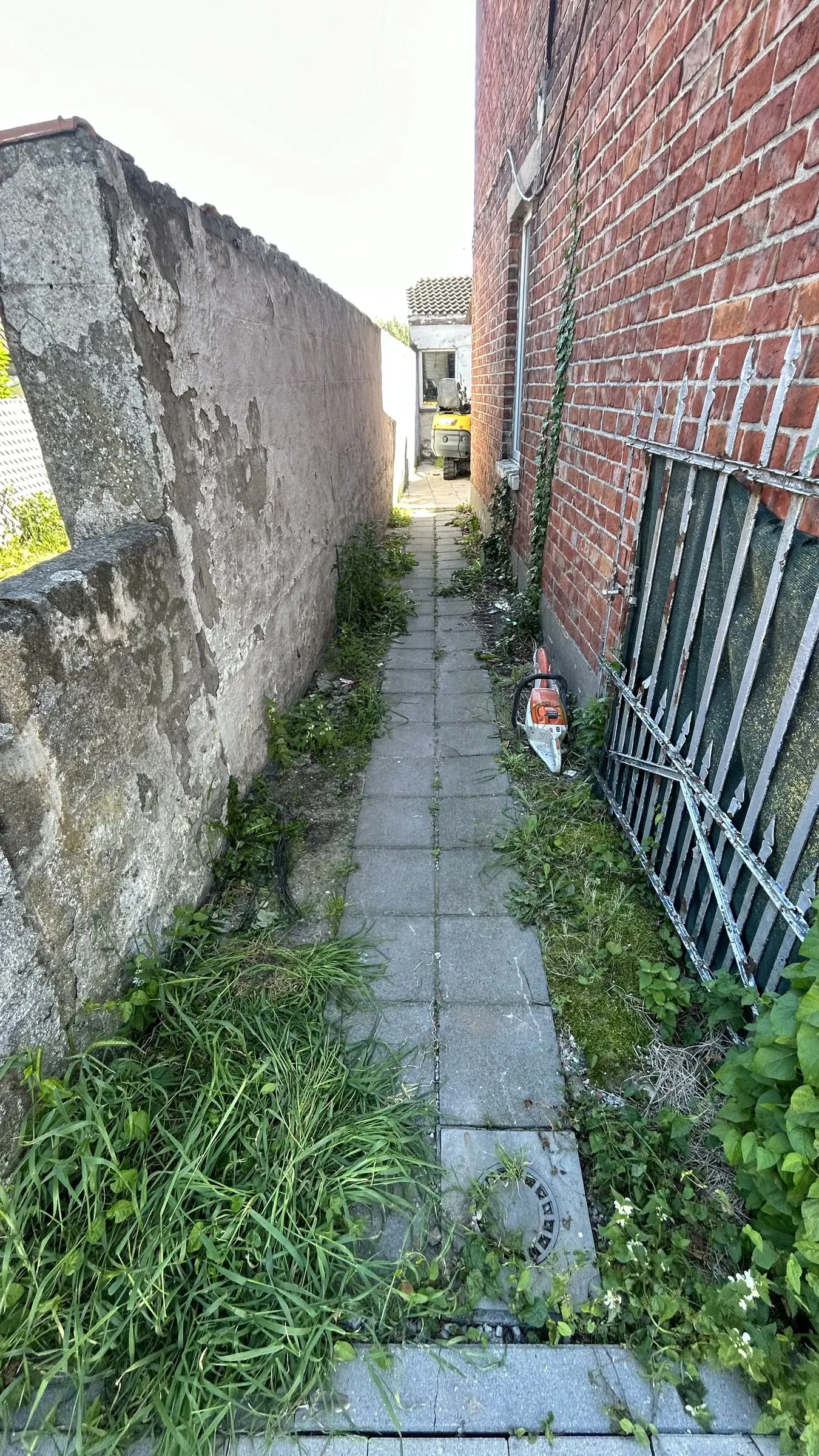 Smal zijpad langs de woning voor de werken
