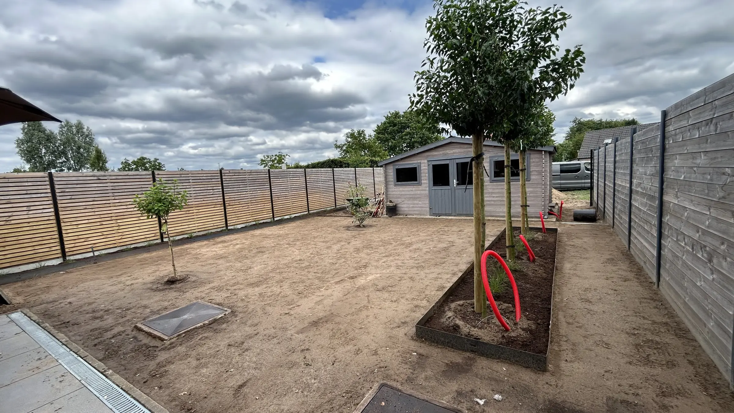 Zicht naar de tuinberging met opgekuiste grond en border