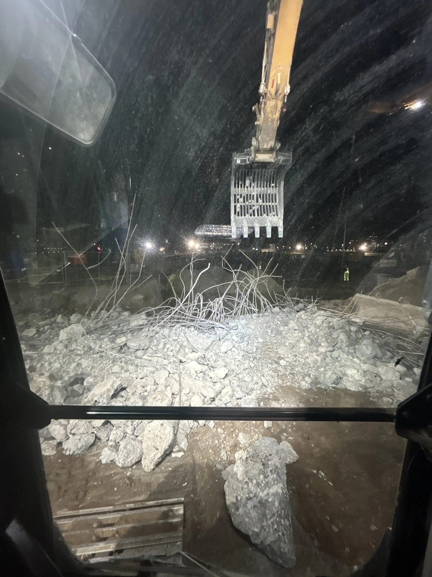 Sloopgrijper vult met gebroken beton en wapening